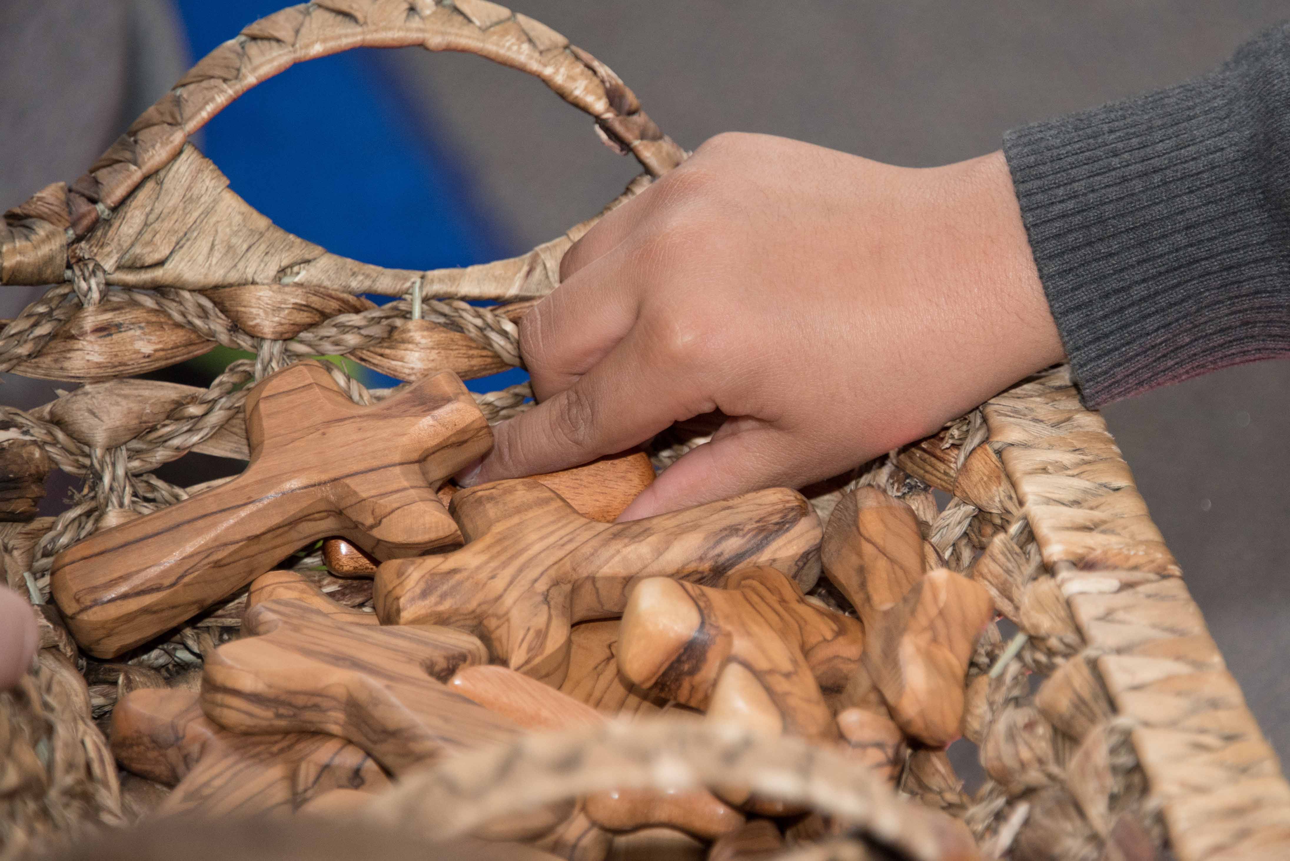 Children are encouraged to think about the meaning of Jesus death as they hold crosses made from olive wood in Israel. 