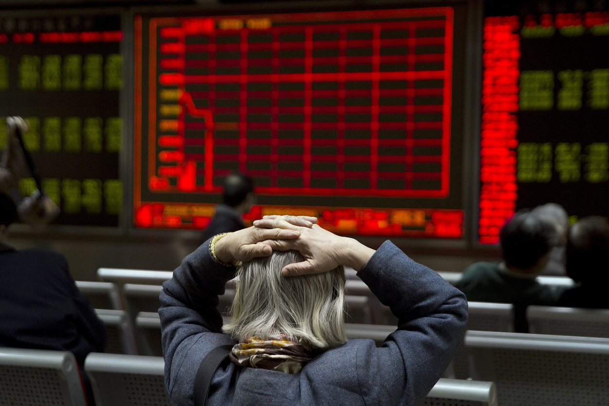 A lady watches the recent dip in the Chinese stock market. See Photo Credits.