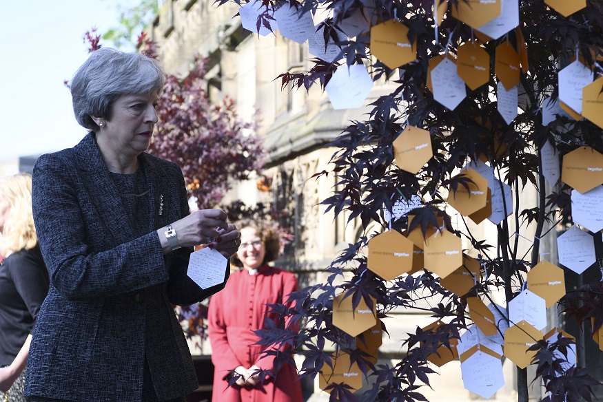 The Prime Minister adds her condolences to a 'Tree of Hope' in Manchester. See Photo Credits.