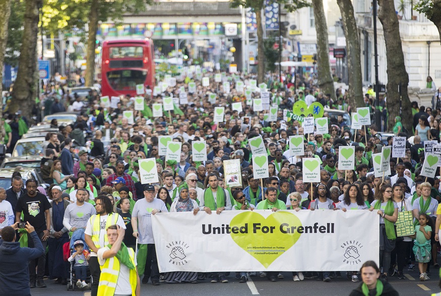 Thousands join a silent march marking one year since the blaze.