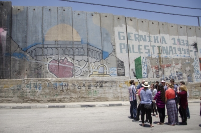 A Fatah representative addresses the group beside the security wall.