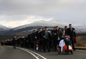 Servicemen and veterans march to the Spean Bridge memorial.