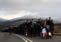 Servicemen and veterans march to the Spean Bridge memorial.