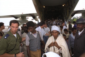 An IDF soldier helps Ethiopian immigrants during Operation Solomon, 1991