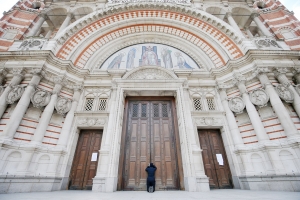 A woman prays at the closed doors of Westminster Cathedral
