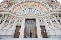 A woman prays at the closed doors of Westminster Cathedral